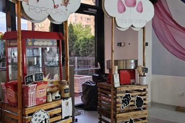 Două standuri pe paleți cu aparat pentru popcorn, aparat pentru vată de zahăr și panouri în formă de nor