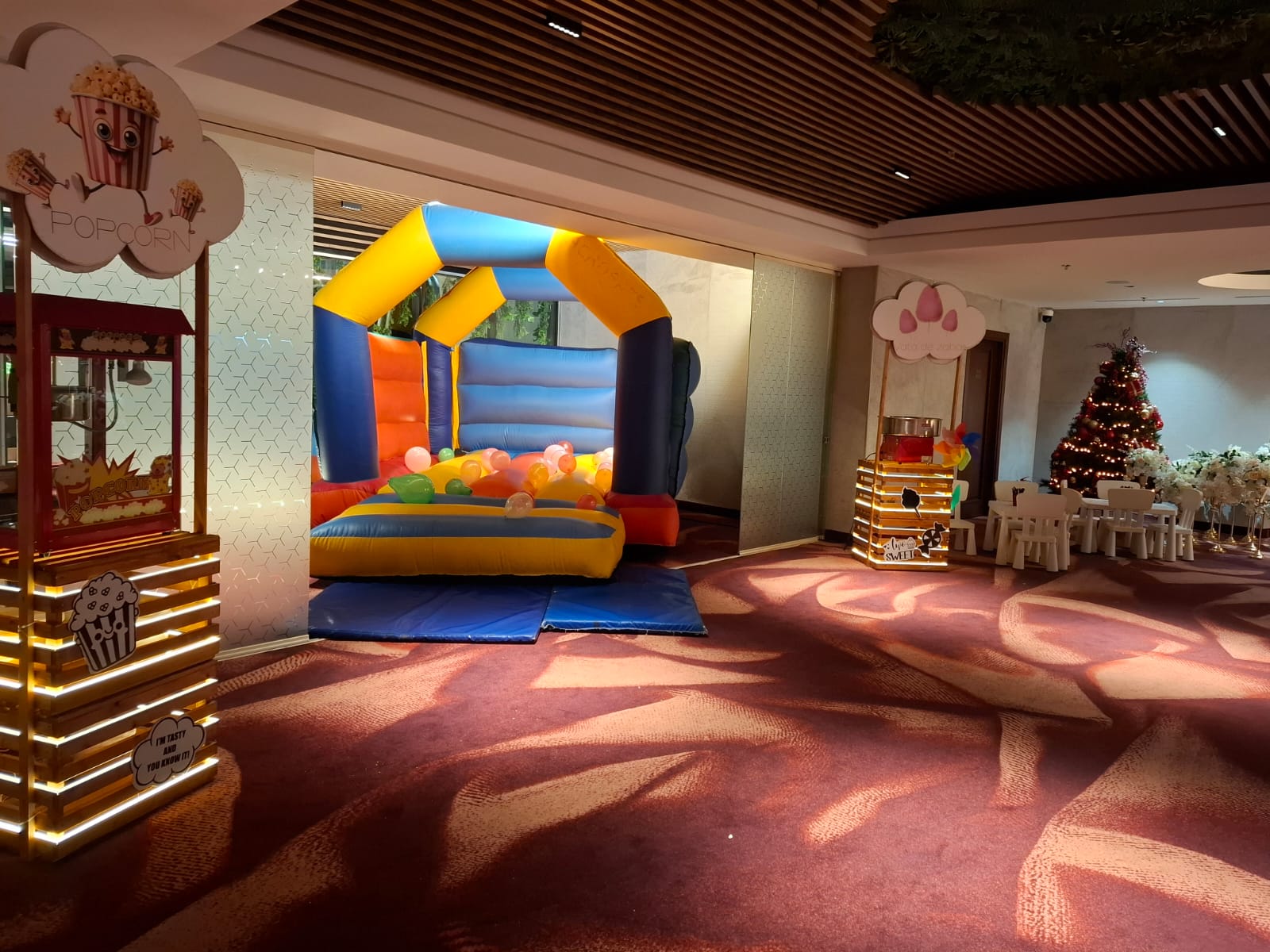 Kids Corner petreceri: castel gonflabil colorat, stand popcorn și vată de zahăr, mese și scaune mici, brad de Crăciun luminat
