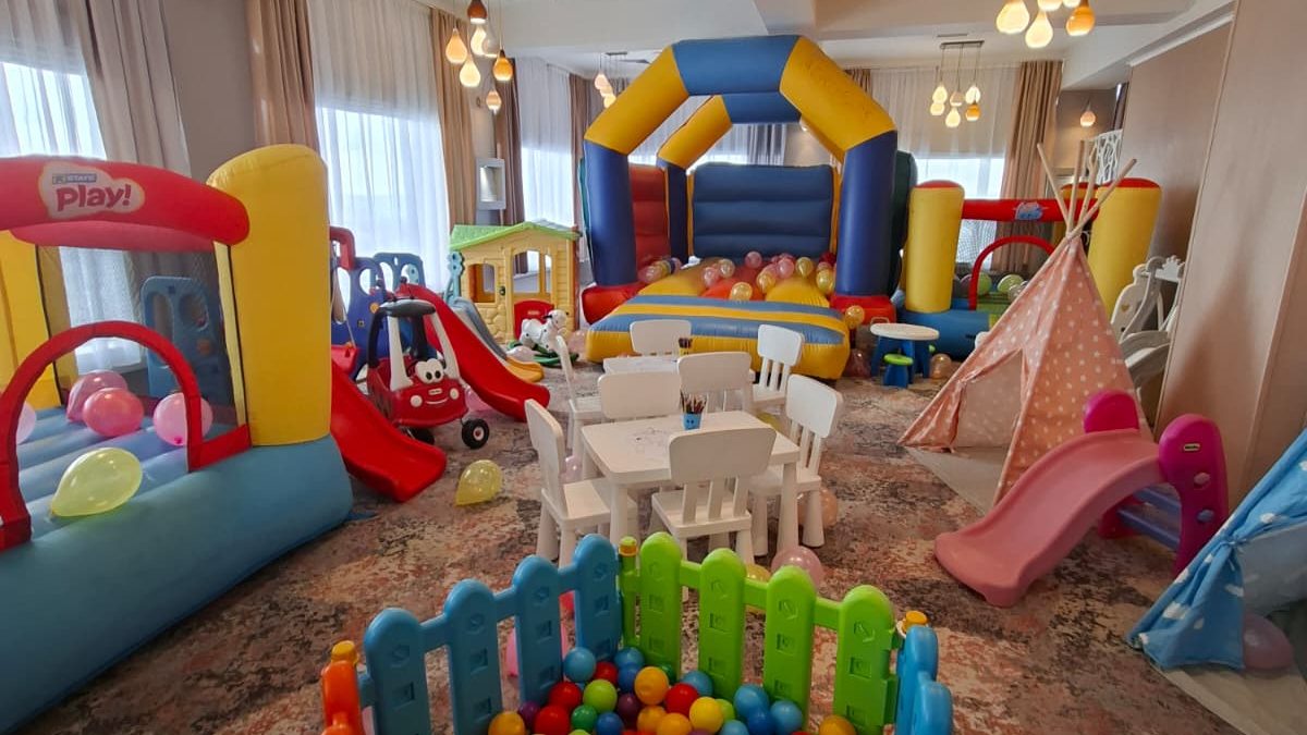 Sală de joacă interior cu casă gonflabilă, bazin de bile, tobogane, mese și cort tipi, fără persoane
