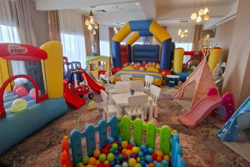 Sală de joacă interior cu casă gonflabilă, bazin de bile, tobogane, mese și cort tipi, fără persoane