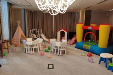 Interior cu colț de joacă: mese de desen, cort teepee, casuță, tobogane și gonflabil colorat