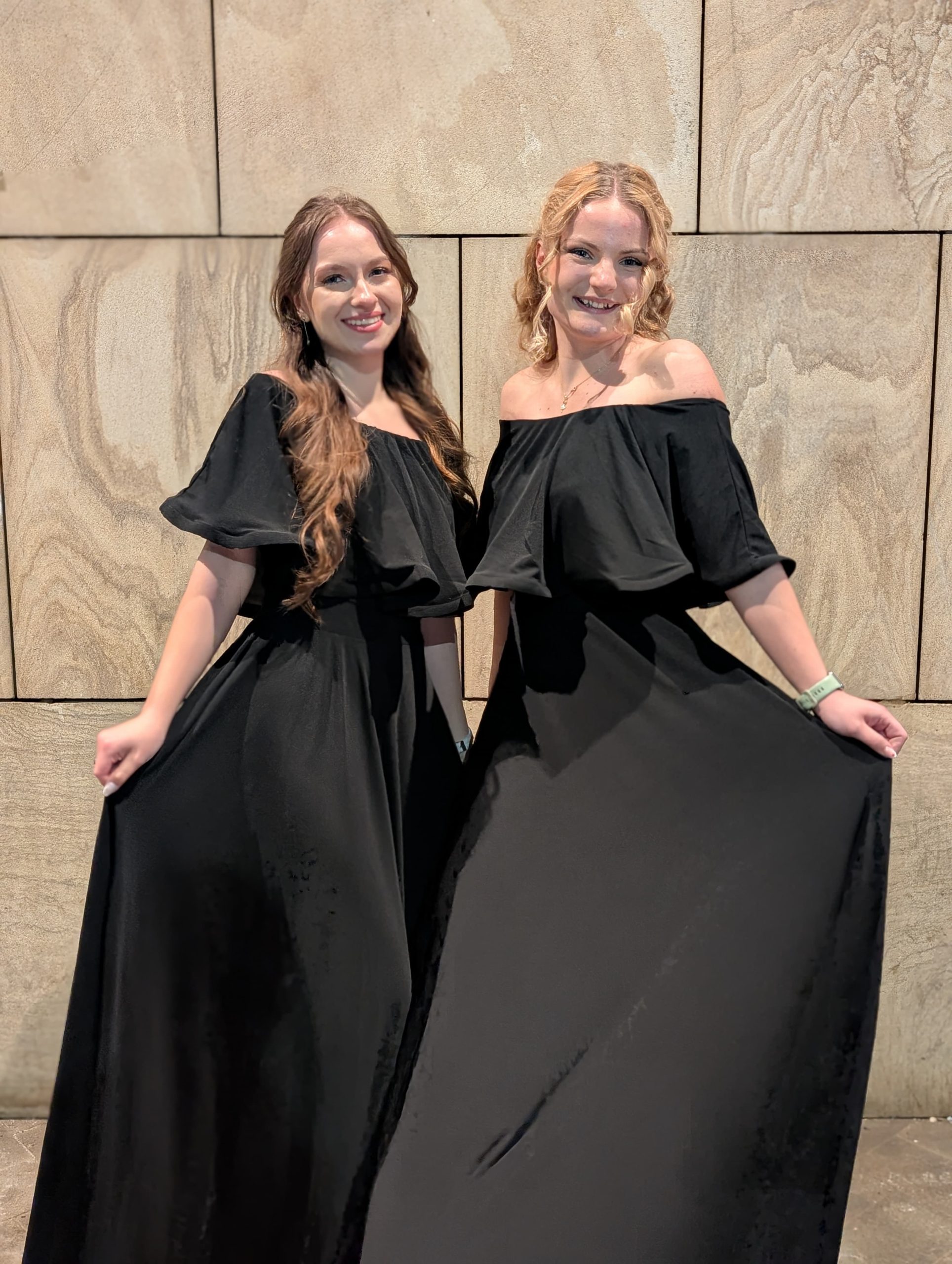 două hostess elegante în rochii negre