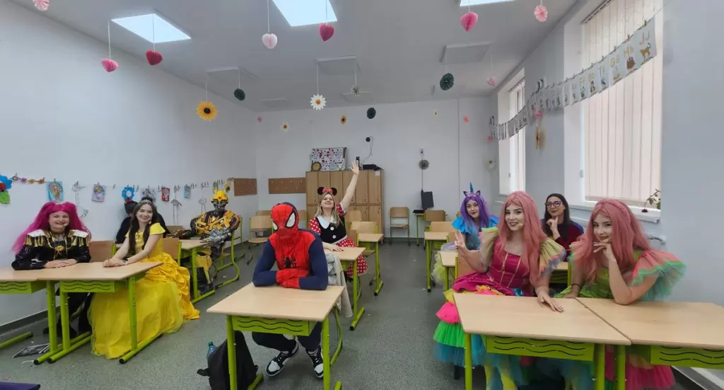 Animatori Kids Mania costumați în Spiderman, Belle și prințese, în băncile unei săli de clasă