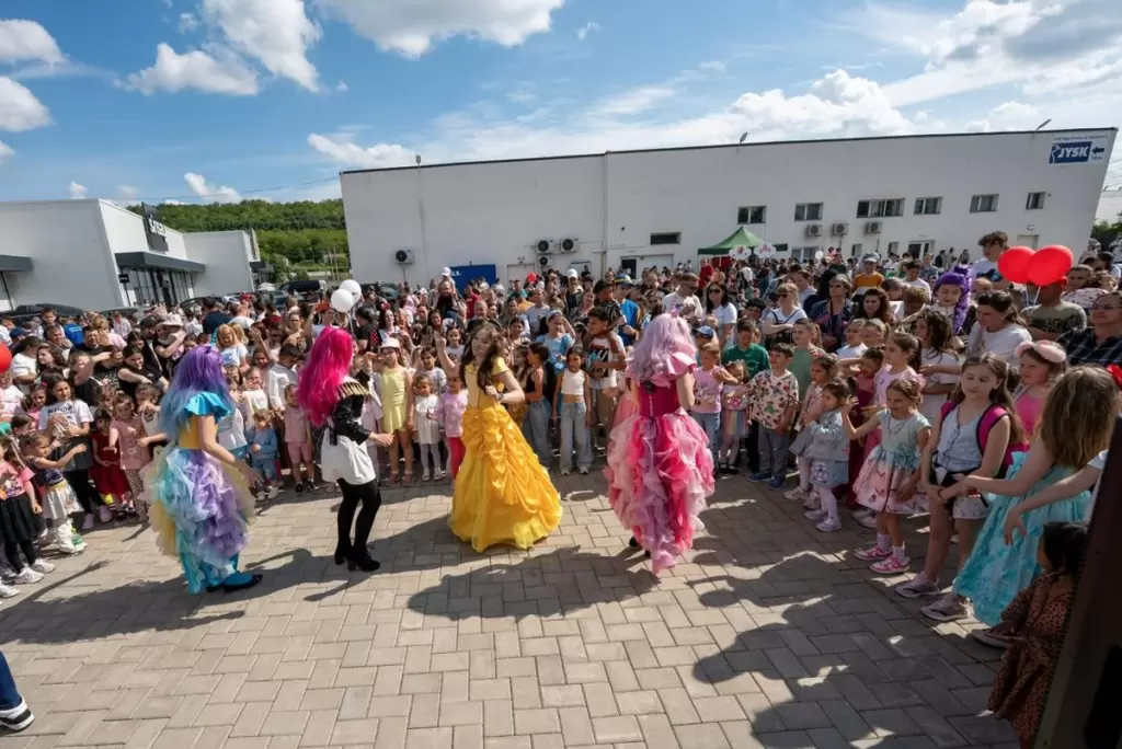 Sute de copii și părinți la un family day al unei companii, animat de Kids Mania
